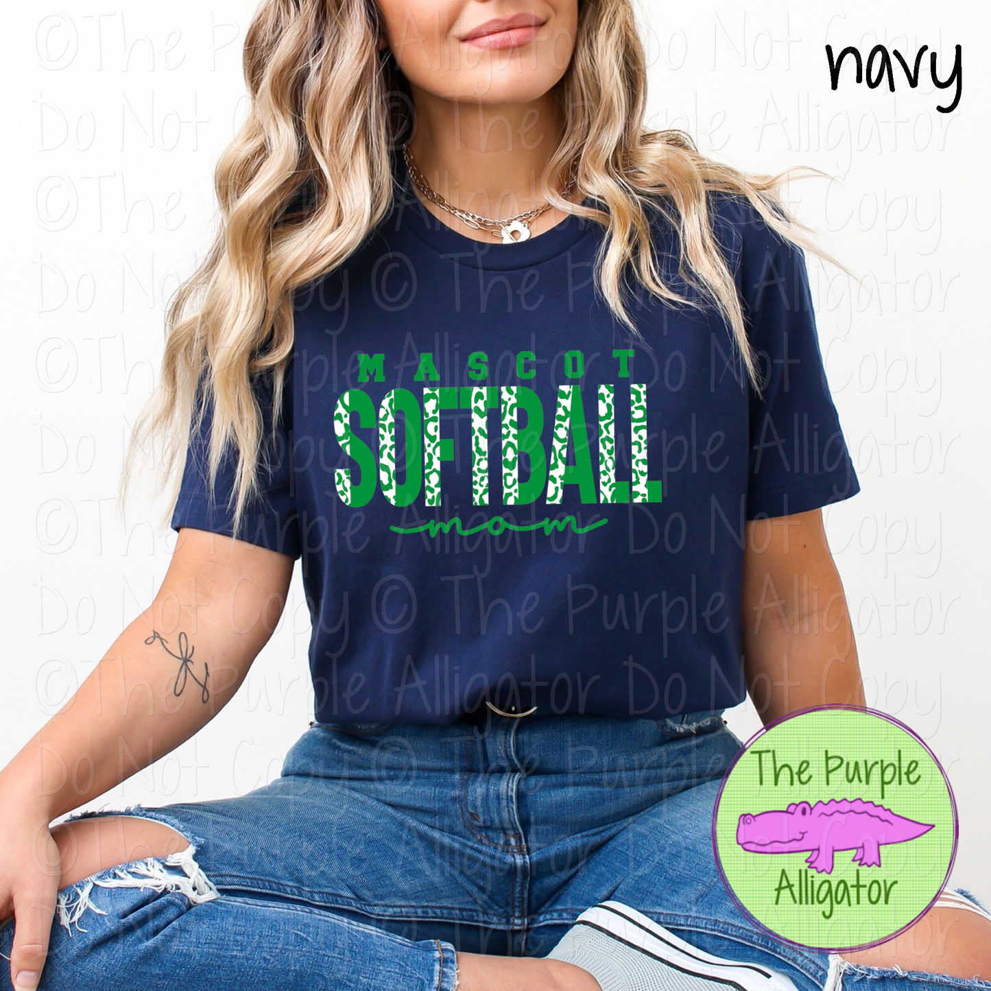 Woman wearing a navy t-shirt with 'Mascot Softball Mom' text and 'The Purple Alligator' logo.